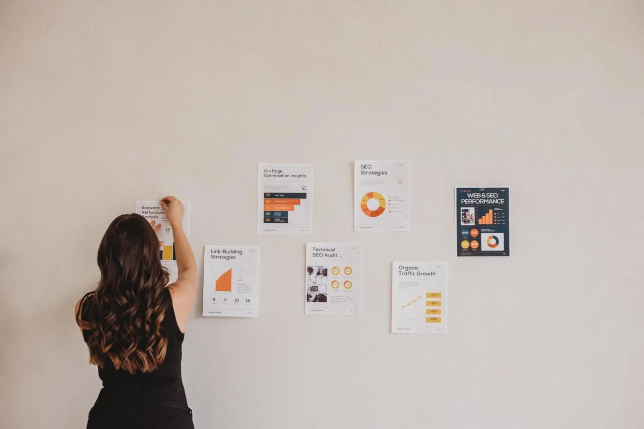Woman arranging SEO strategy and performance charts on a wall