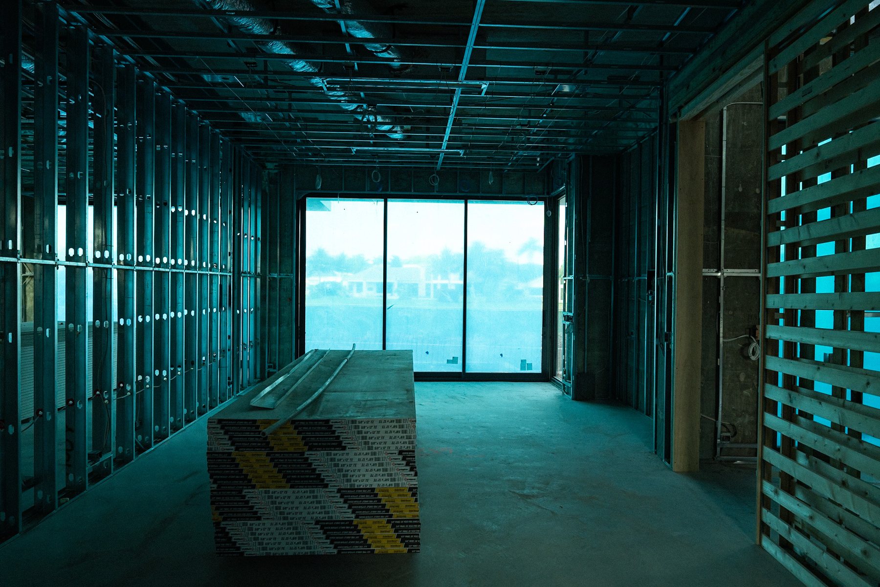 Light-filled interior under construction with exposed framing