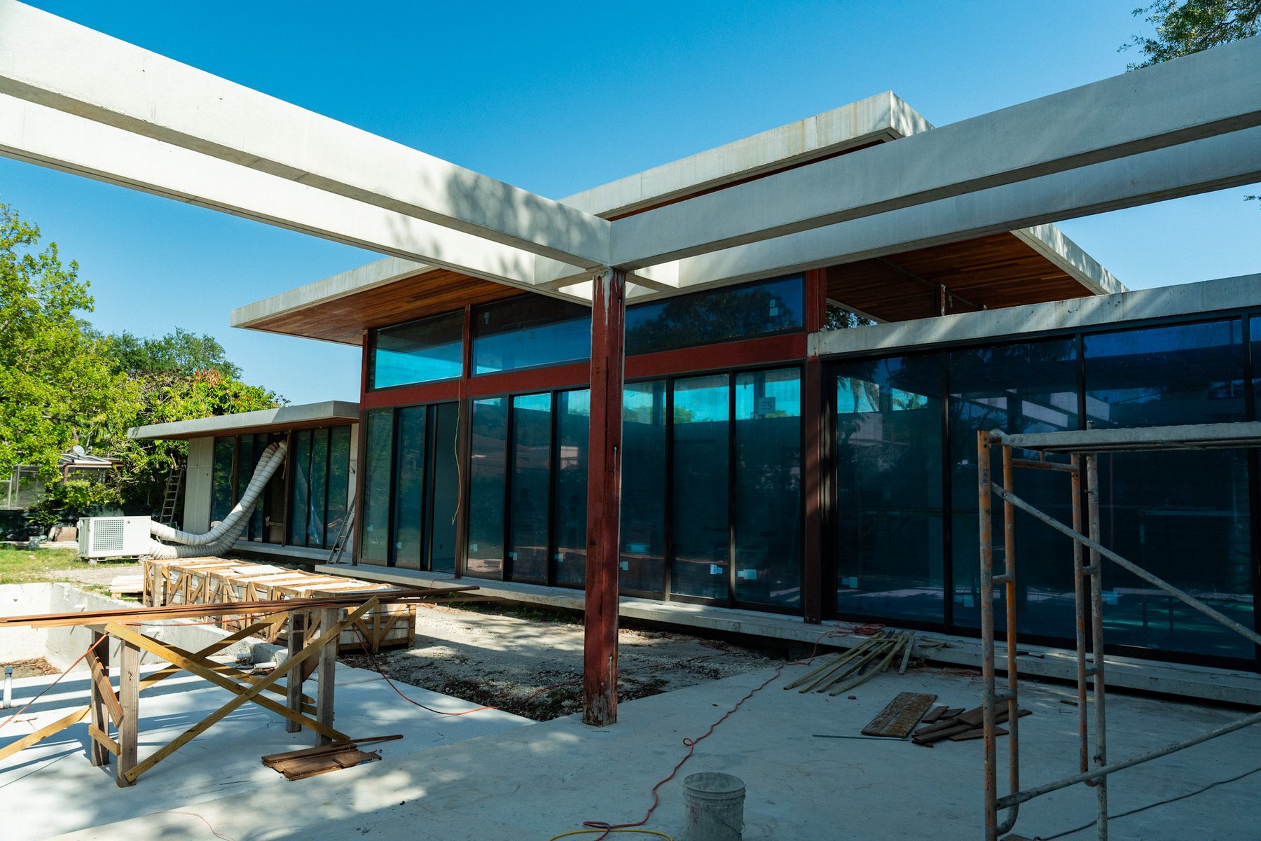 Contemporary structure in progress beneath a wood roofline