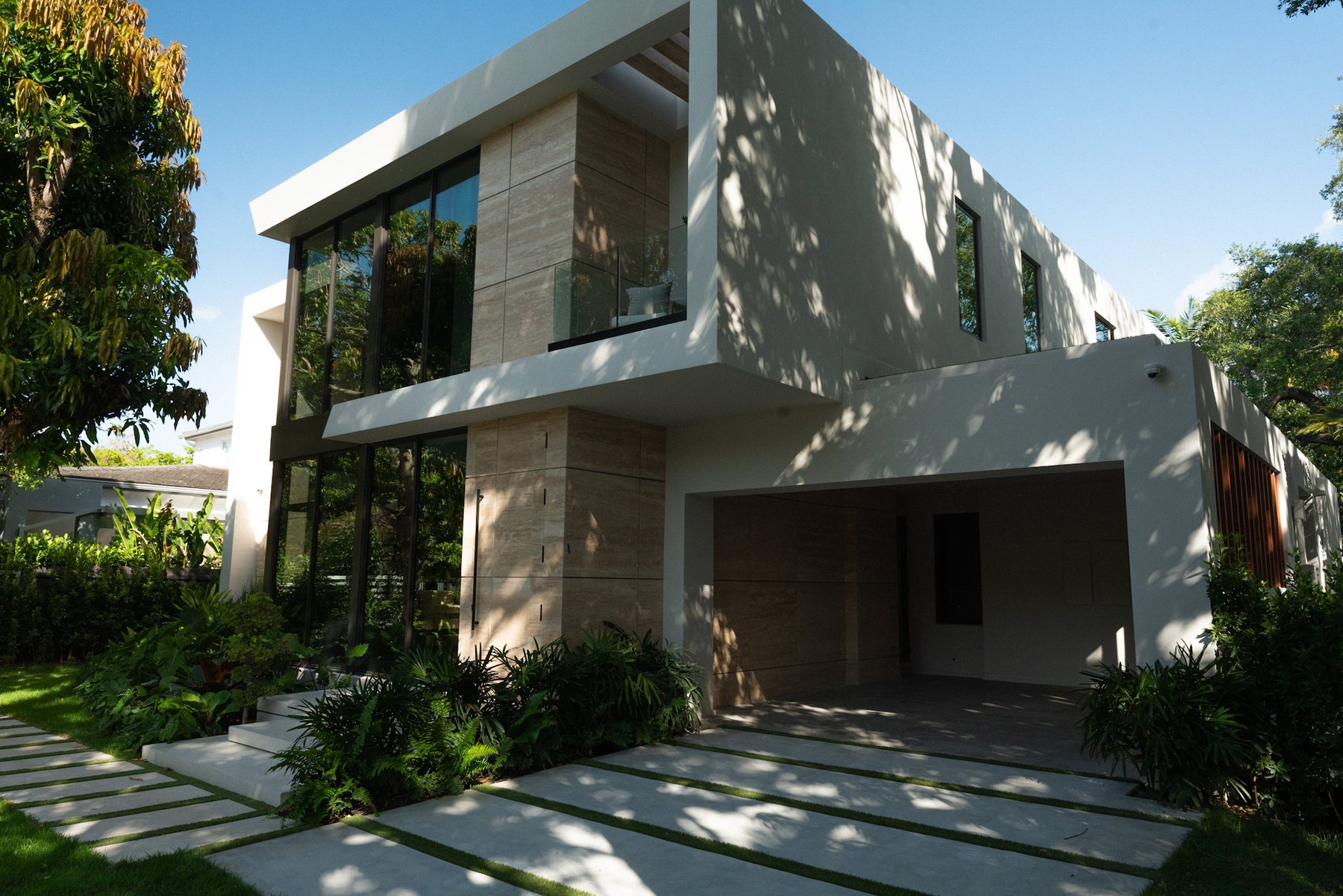 Contemporary Miami residence framed by mature tropical trees